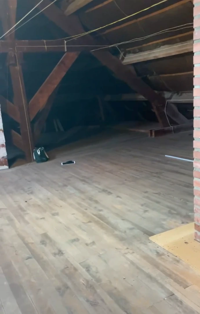 Avant : combles bruts avant aménagement poutres apparentes